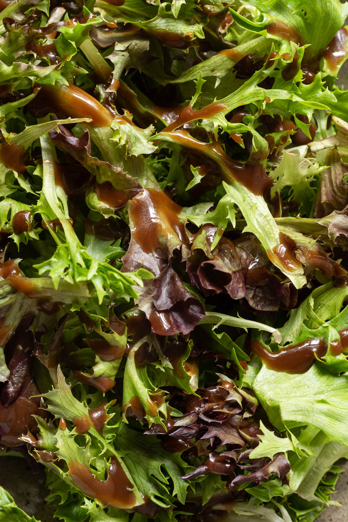 A salad topped with balsamic vinaigrette.