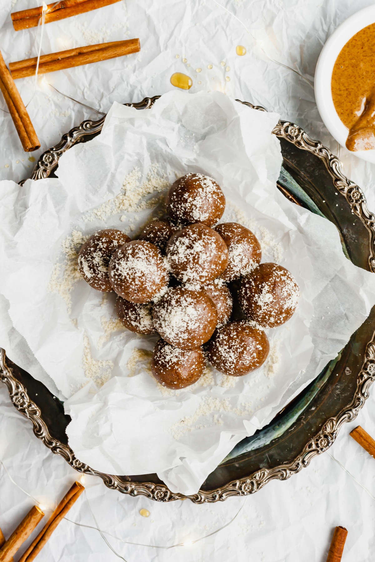 A pile of gingerbread energy balls on a tray with parchment paper on top.