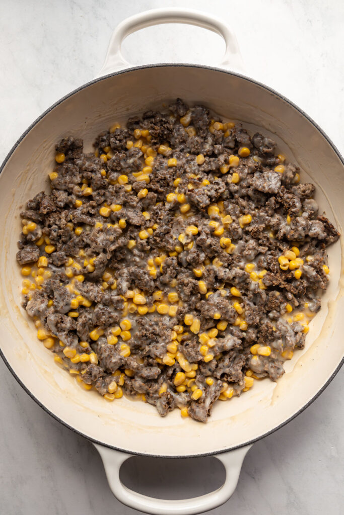 Meatless crumble, corn, and gravy in a braiser.