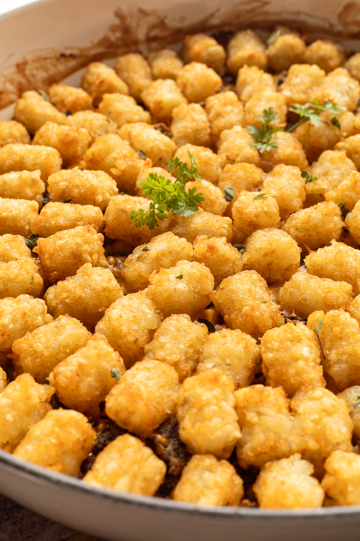 Close up side view of tater tot casserole in a braiser.