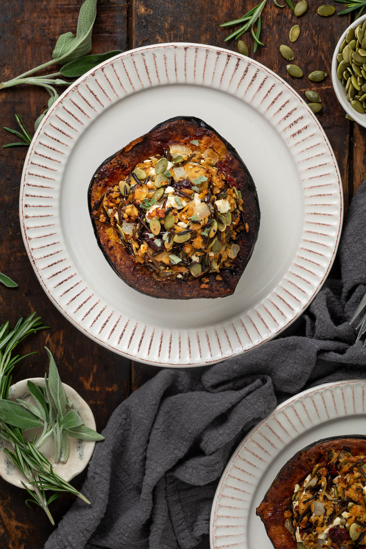 Top view of a stuffed acorn squash on a white plate.