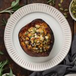 Top view of a stuffed acorn squash on a white plate.