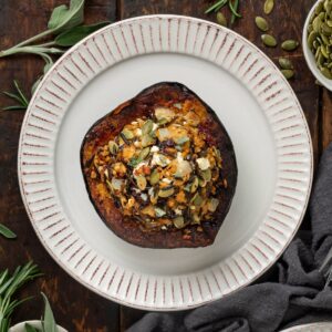 Top view of a stuffed acorn squash on a white plate.