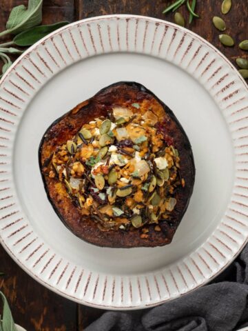 Top view of a stuffed acorn squash on a white plate.