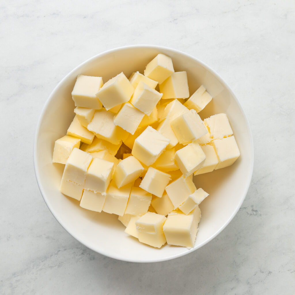 a bowl of butter cut into cubes.