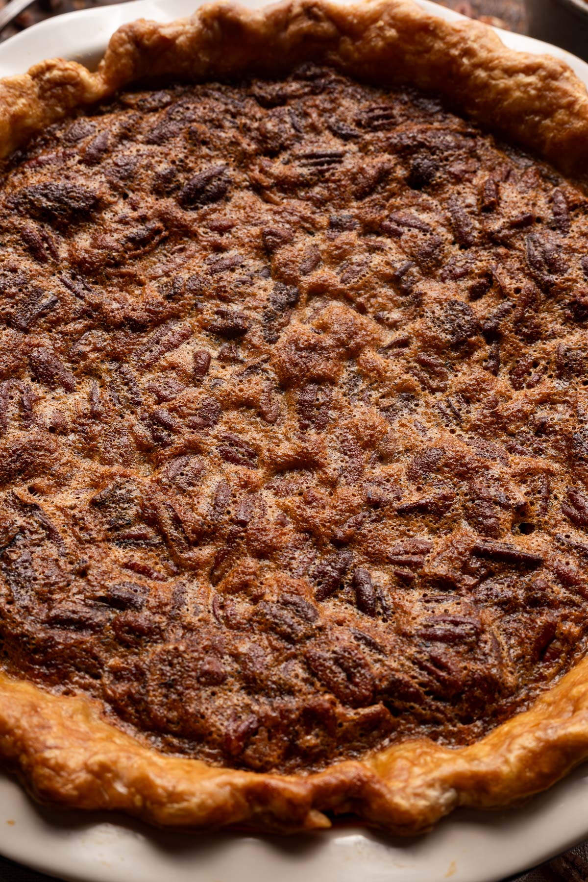 close up image of chocolate bourbon pecan pie in the pan.