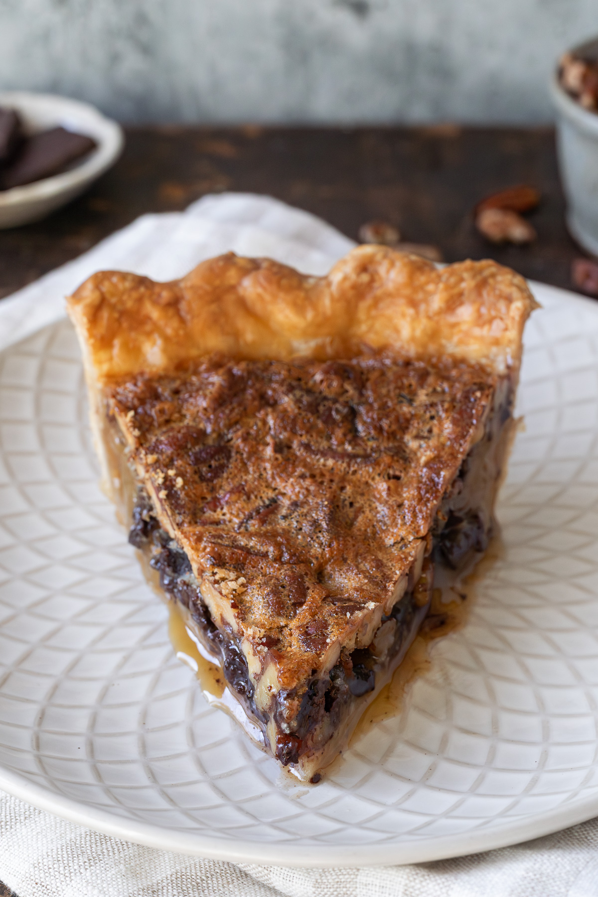 a slice of chocolate bourbon pecan pie on a small plate.