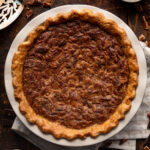 chocolate bourbon pecan pie on a wood table with a white striped napkin.