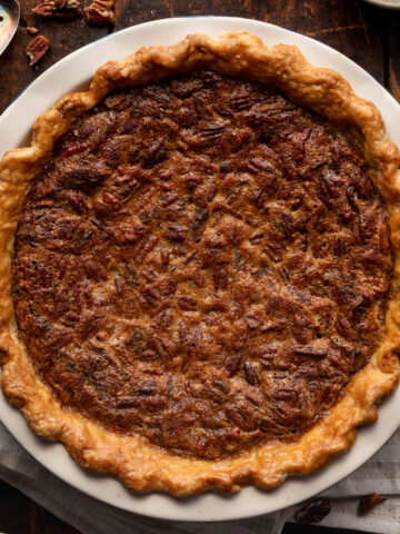 chocolate bourbon pecan pie on a wood table with a white striped napkin.