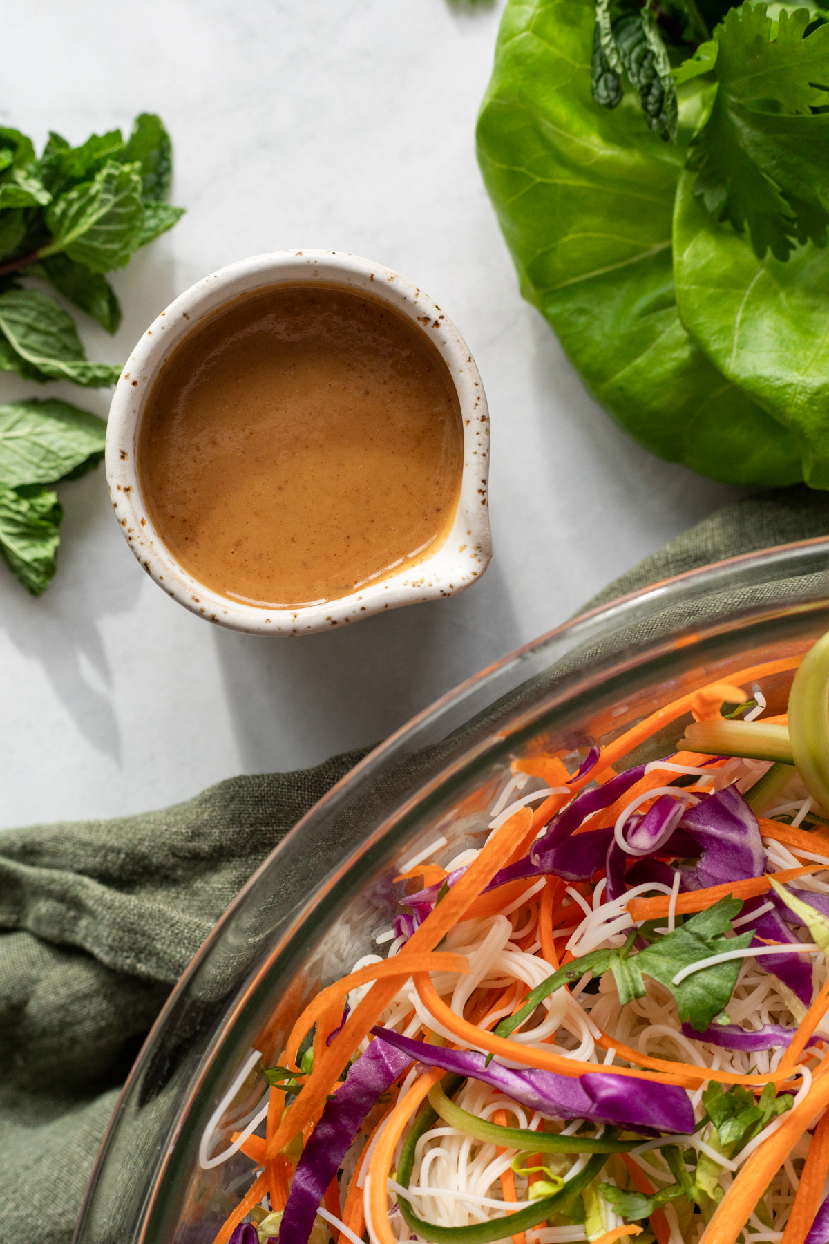 Peanut dressing in a small ceramic cup with a spout.