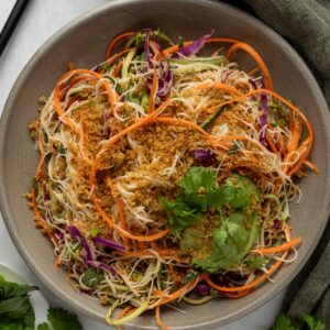 Ingredients to make a spring roll salad sectioned in a large mixing bowl.
