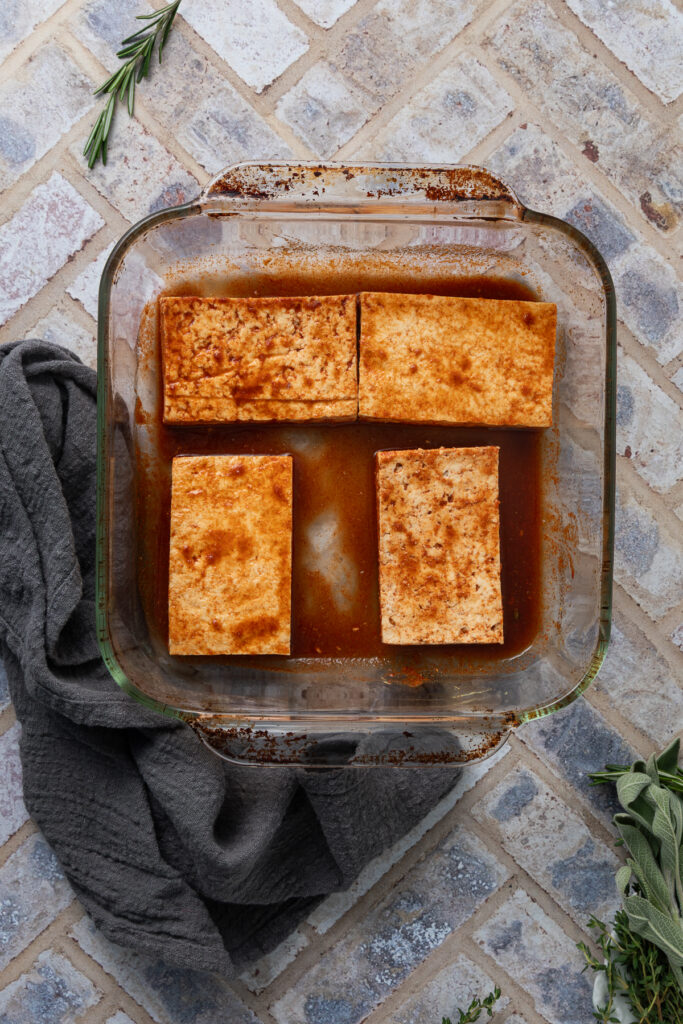 Tofu marinating in a baking dish.