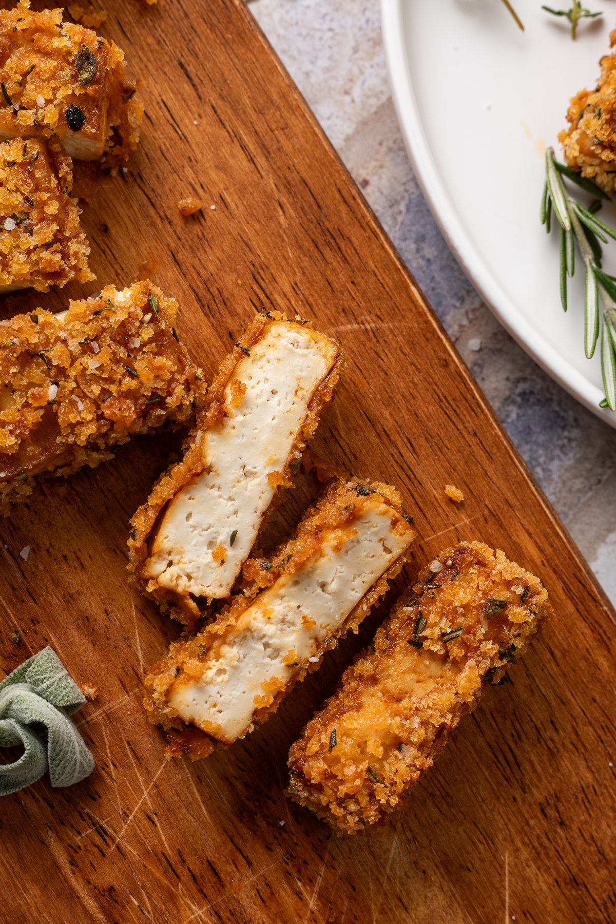 Slices of crispy baked tofu on a cutting board.