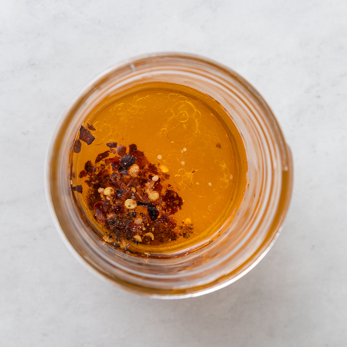 A small jar of sun dried tomato dressing before it's shaken.