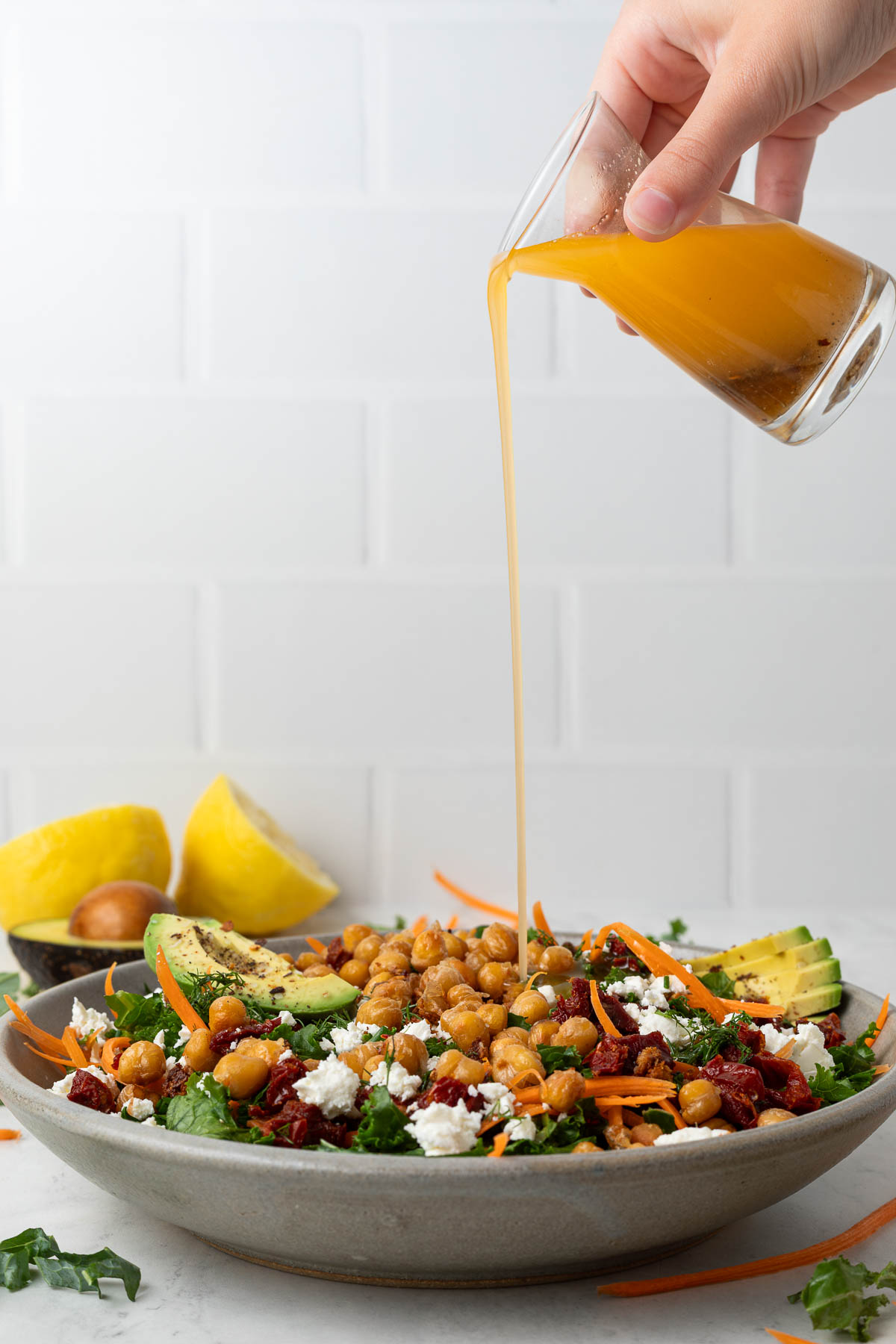 Sun dried tomato dressing being poured on to a salad.