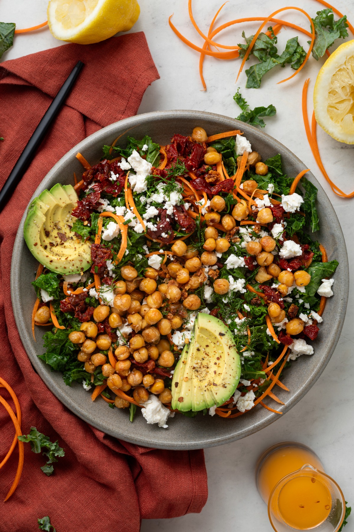 A large serving bowl of chickpea and kale salad on top of a red linen napkin.