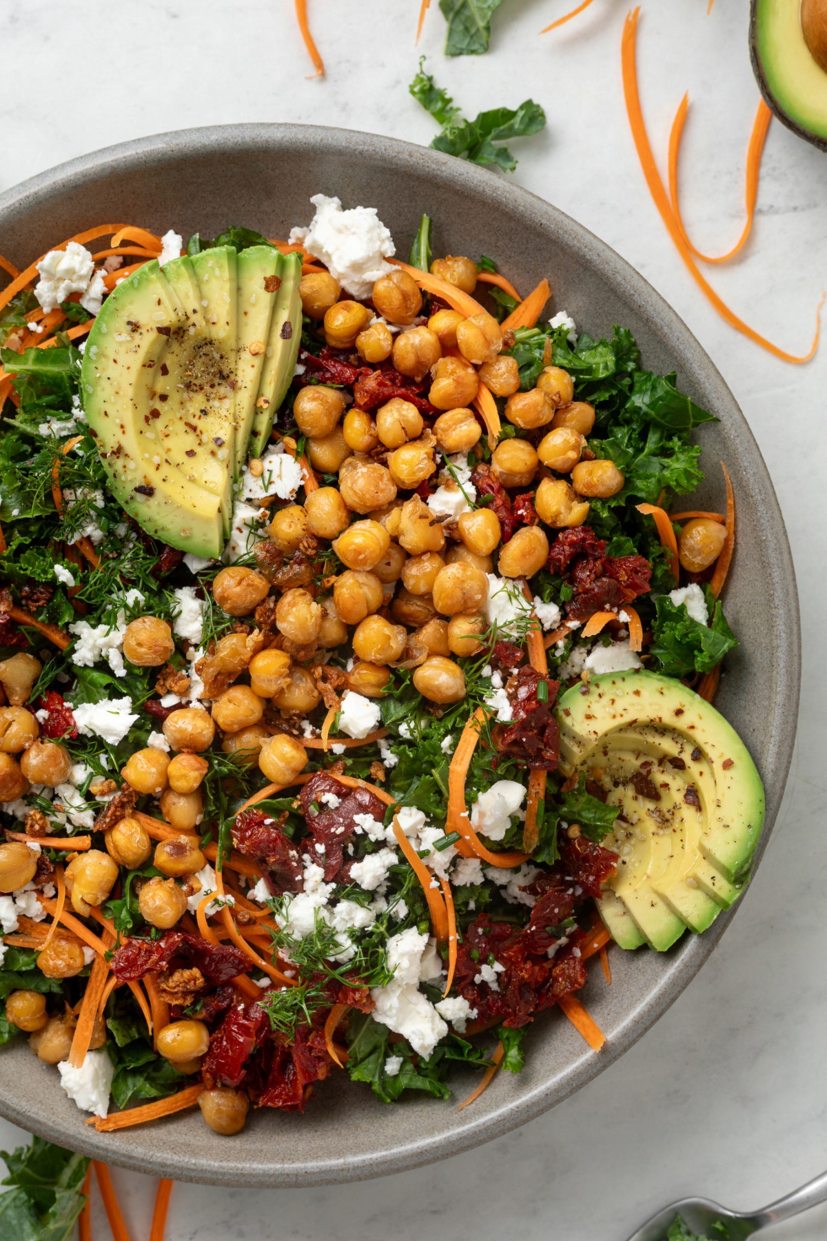 A bowl of chickpea and kale salad ¾ in the frame.