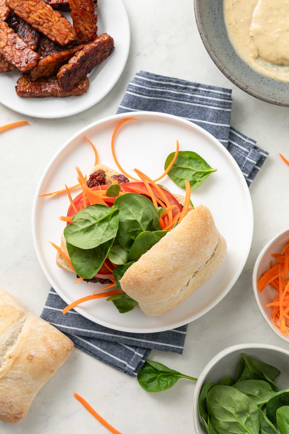 Top view of a tempeh sandwich on a plate.