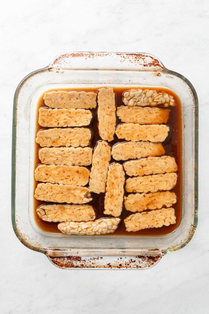Tempeh marinating in a baking dish.